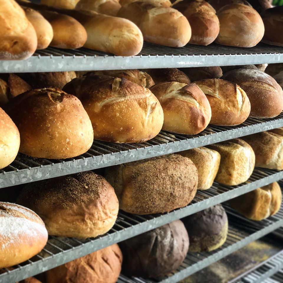 Racks of fresh-baked sourdough and rustic country loaves at Wheatland Bakery